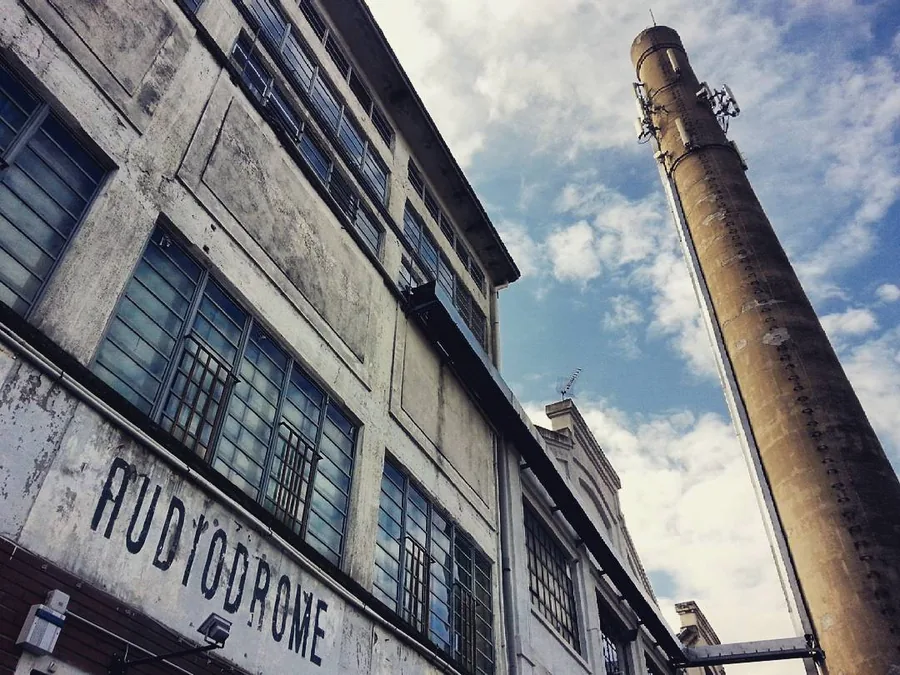 La facciata della fabbrica Audiodrome con la ciminiera